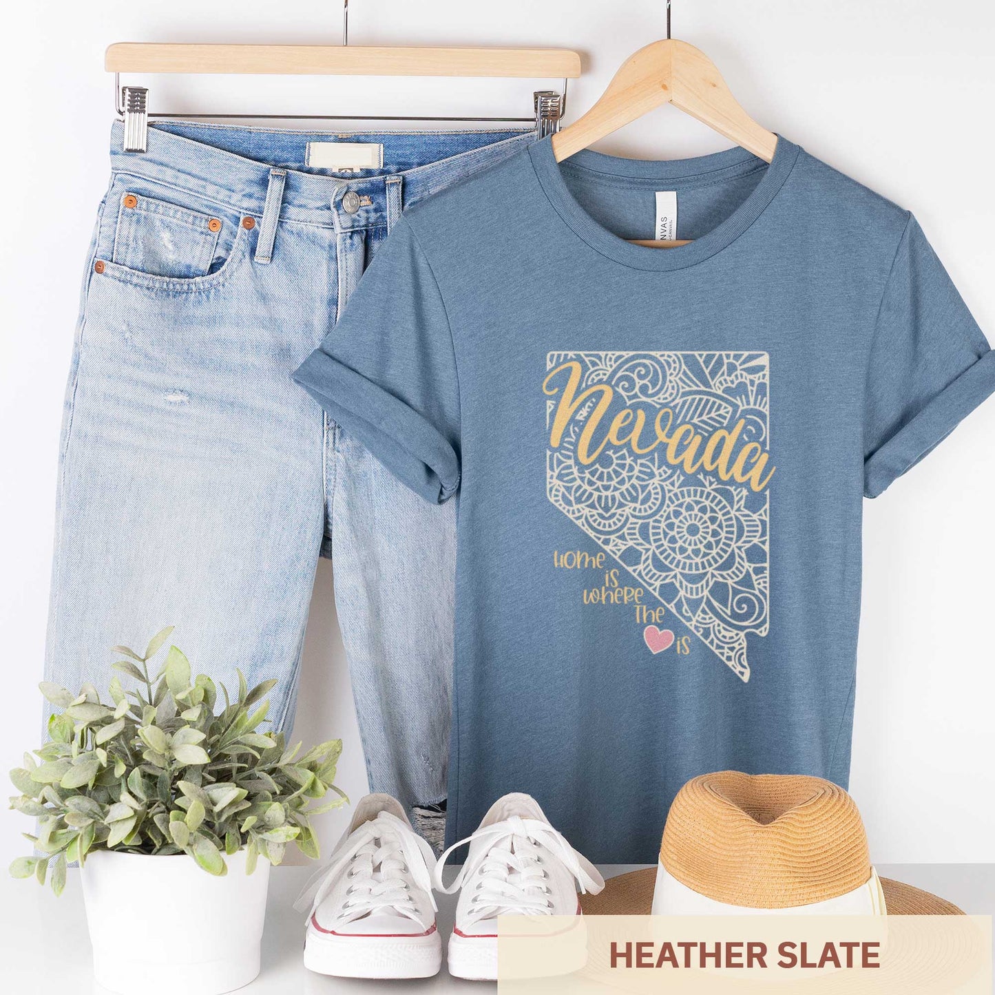 A hanging heather slate Bella Canvas t-shirt featuring a mandala in the shape of Nevada with the words home is where the heart is.