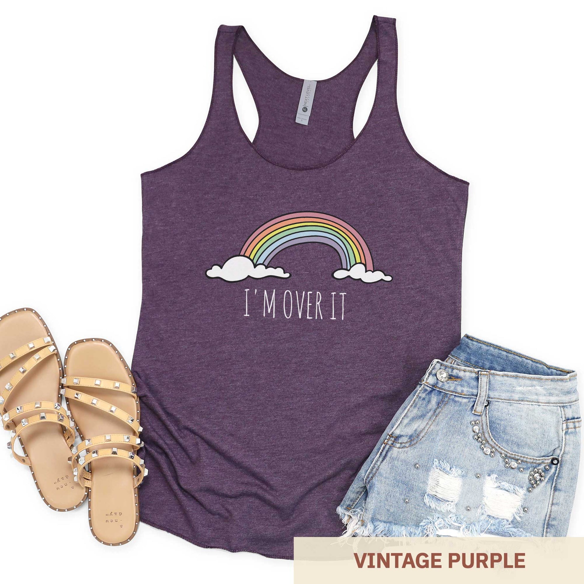 A vintage purple Next Level triblend racerback tank top featuring a rainbow and clouds and the words i'm over it.