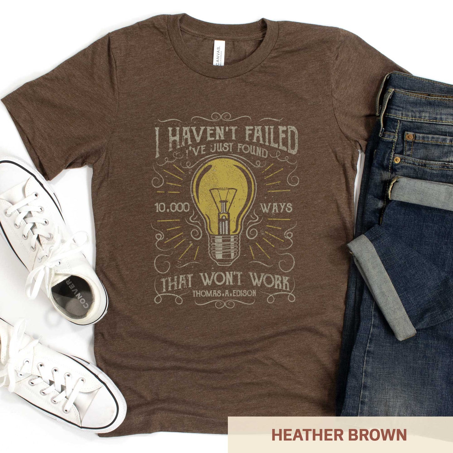 A heather brown Bella Canvas t-shirt featuring a lightbulb in a distressed, vintage style along with the words I haven't failed I've just found 10,000 ways that wont work Thomas A. Edison.