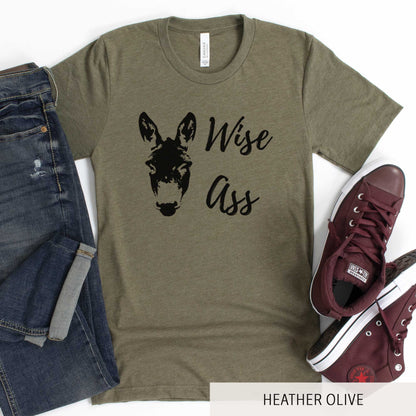 A heather olive Bella Canvas t-shirt featuring a donkey and the words wise ass.