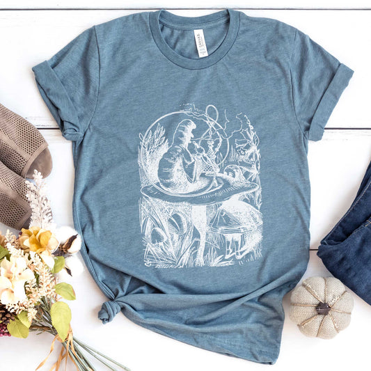 A heather slate Bella Canvas t-shirt featuring the John Tenniel illustration of Alice in Wonderland meeting the caterpillar who is sitting on a mushroom.