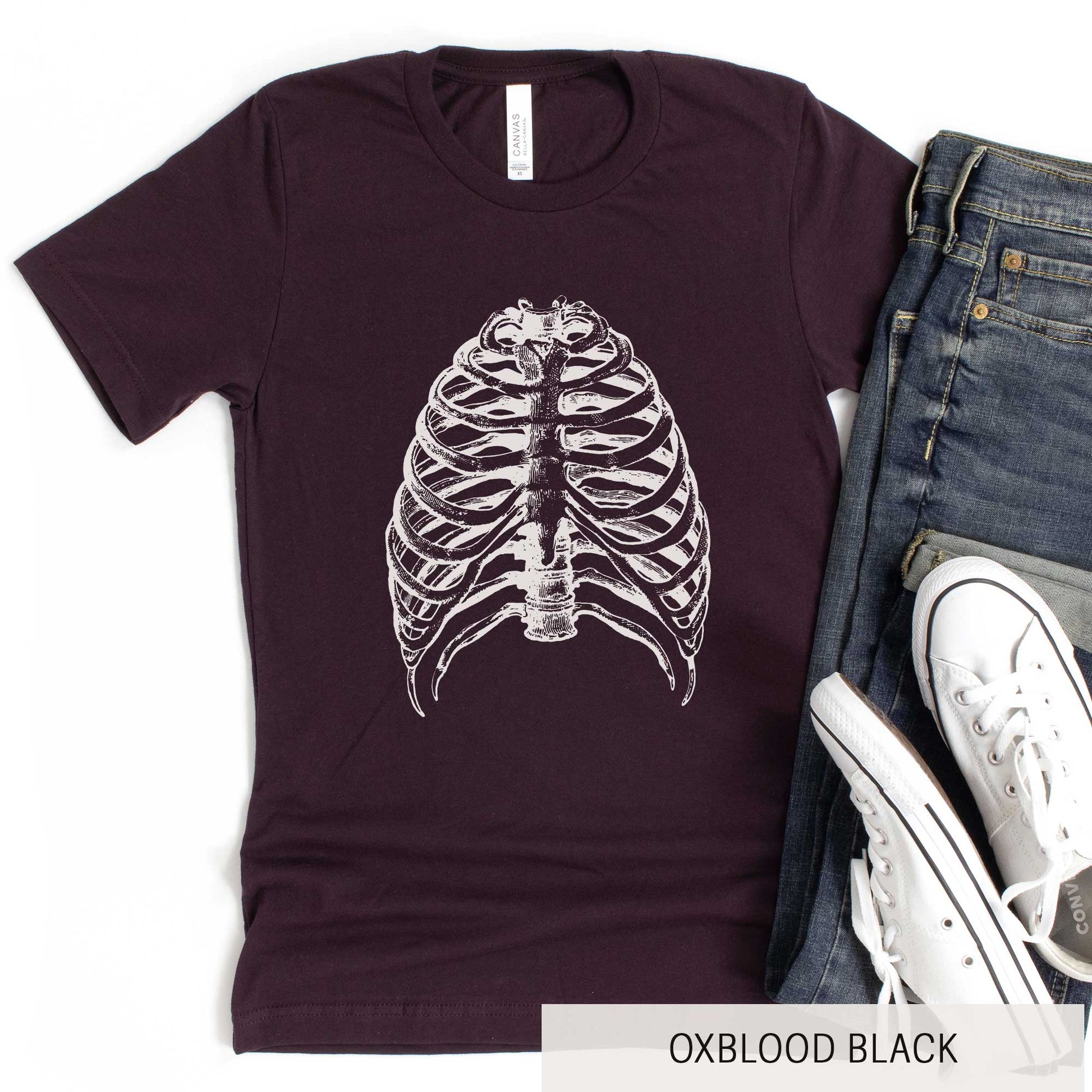 An oxblood black Bella Canvas t-shirt featuring a vintage illustration of a skeletons rib cage.