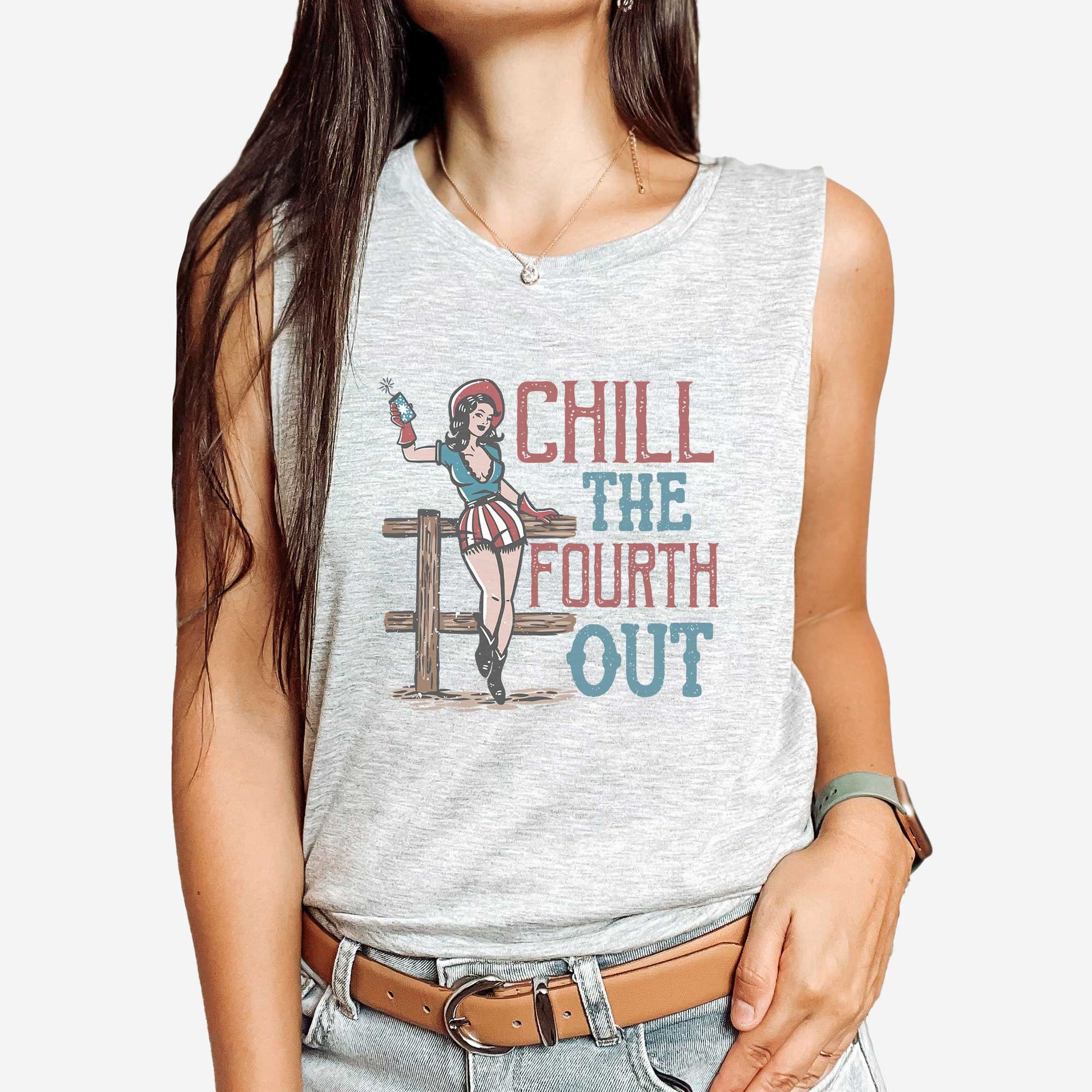 A woman wearing an athletic grey Bella Canvas muscle tank featuring a retro cowgirl and the words chill the fourth out in muted red, white and blue colors.