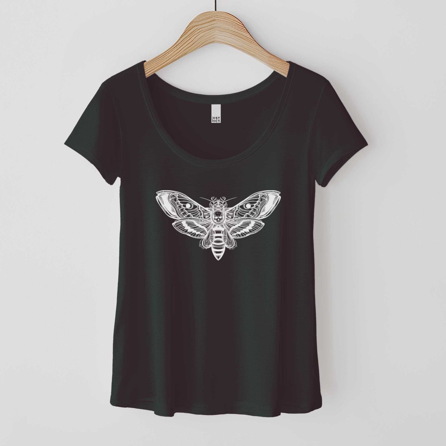 A hanging black District 7501 scoop neck t-shirt featuring a white silhouette of a death's head moth.