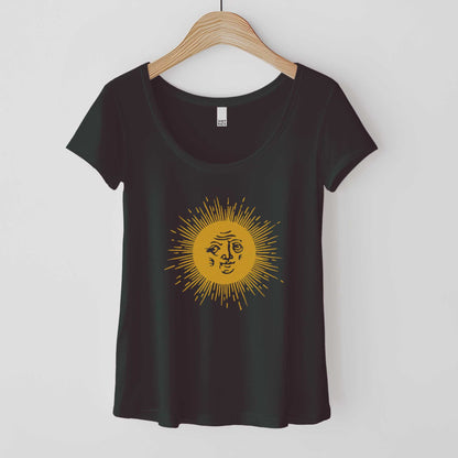 A hanging black District 7501 scoop neck t-shirt featuring a medieval woodcut illustration of the sun with a face inside.