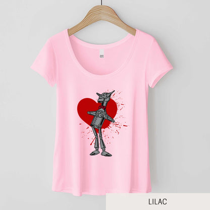 A hanging lilac District 7501 scoop neck t-shirt featuring a vintage Denslow illustration of the tin man from the Wizard of Oz with a heart symbol spattered behind him.