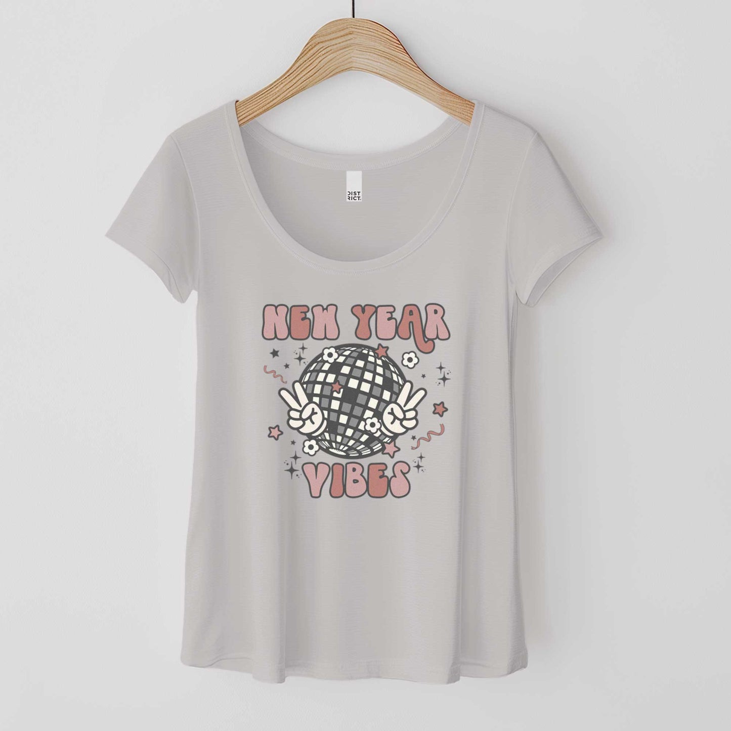 A hanging silver mist District 7501 scoop neck t-shirt featuring a retro disco ball flashing a peace sign and the words new year vibes.