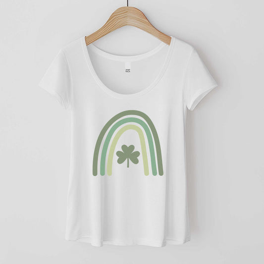 A hanging white District 7501 scoop neck t-shirt featuring a green colored rainbow with a shamrock in the center.