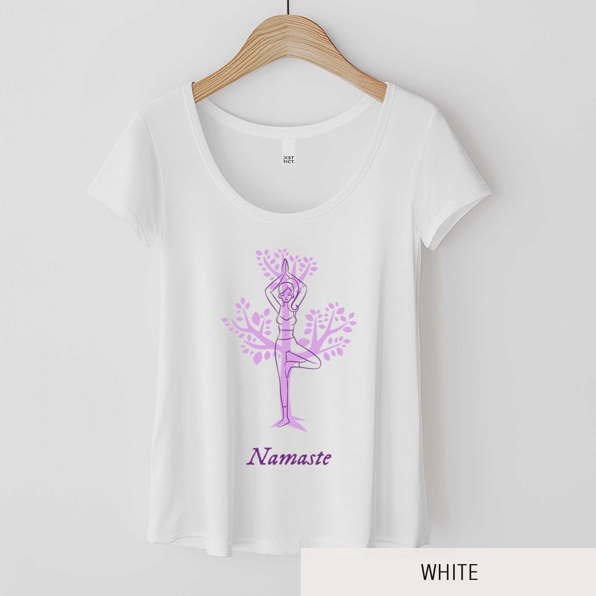 A hanging white District 7501 scoop neck t-shirt featuring a cartoon woman doing the tree pose in front of a tree silhouette and the words namaste below her.