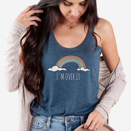 A woman wearing an indigo Next Level triblend racerback tank top featuring a rainbow and clouds and the words i'm over it.